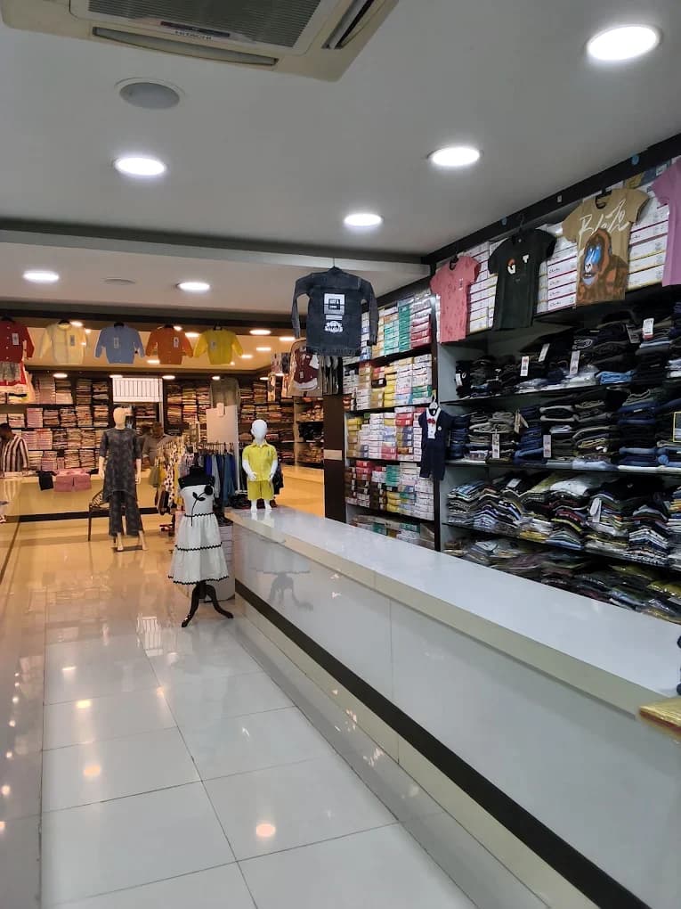 The Laksha Fashion shop floor, with kids' T-shirts and a jacket on display, a child mannequin, and women's ethnic sets on mannequins further back