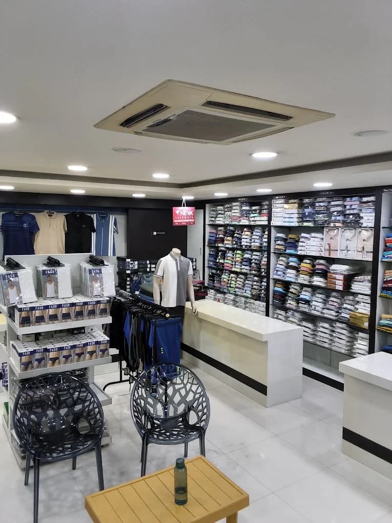 The men's casual section at Laksha Fashion, with polo T-shirts, trousers on a rail, boxed innerwear and shelves of folded shirts